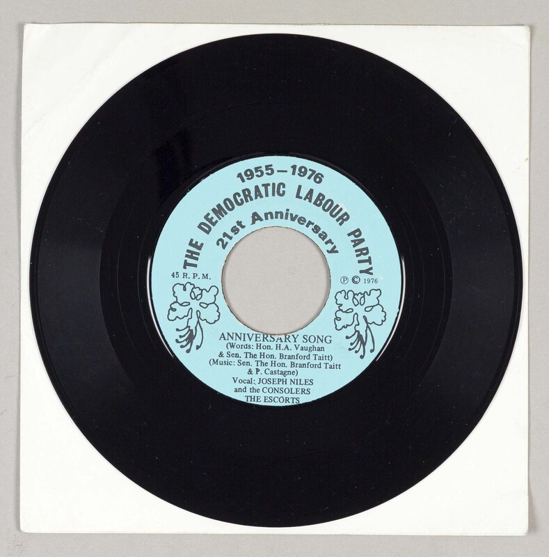 The vinyl has a light blue label with two Dwarf Poinciana flowers on the side, which is the national flower of Barbados. The text says: '1955-1976, The Democratic Labour Party, 21st Anniversary, Anniversary song (Words: Honourable H.A. Vaughan & Senator The Honourable Brandford Taitt and P. Castagne), Vocal: Joseph Niles and the Consolers, the Escorts.