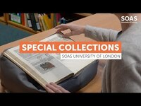 Special collection book places on cushion with hands about to turn a page.