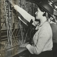 Women telephonists operating a switchboard with steel helmets, 1939-45 (POST 56/14).