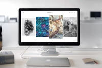 Desktop computer set on a clean white desk with a closed laptop and notebook nearby.